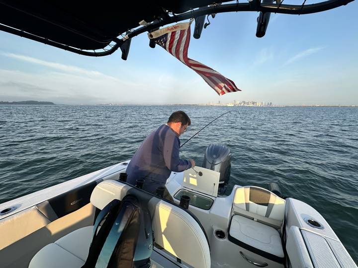 Working a fish off the stern with the city on the horizon