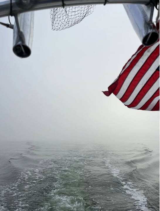 Running home through fog, flag and net over the wake