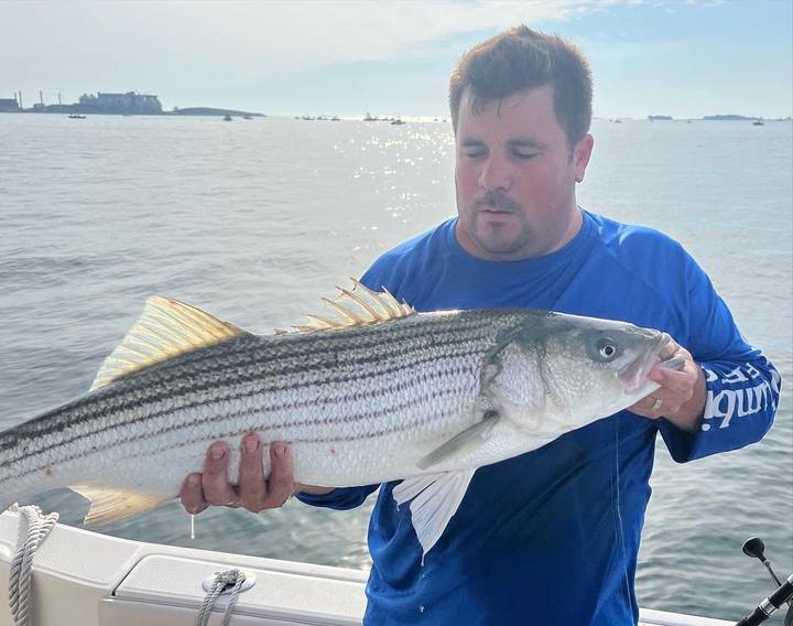 Striper held up with the harbor islands behind