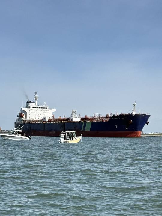 Small boats fishing right under an inbound tanker